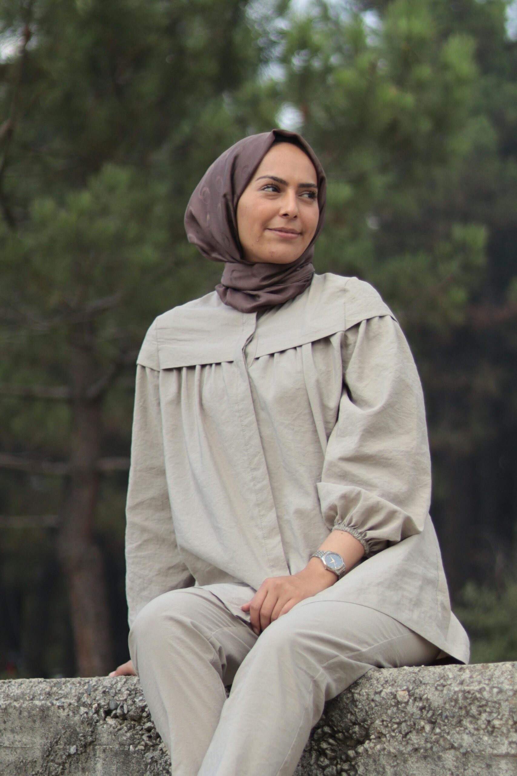 Thoughtful Woman in Hijab Sitting Outdoors